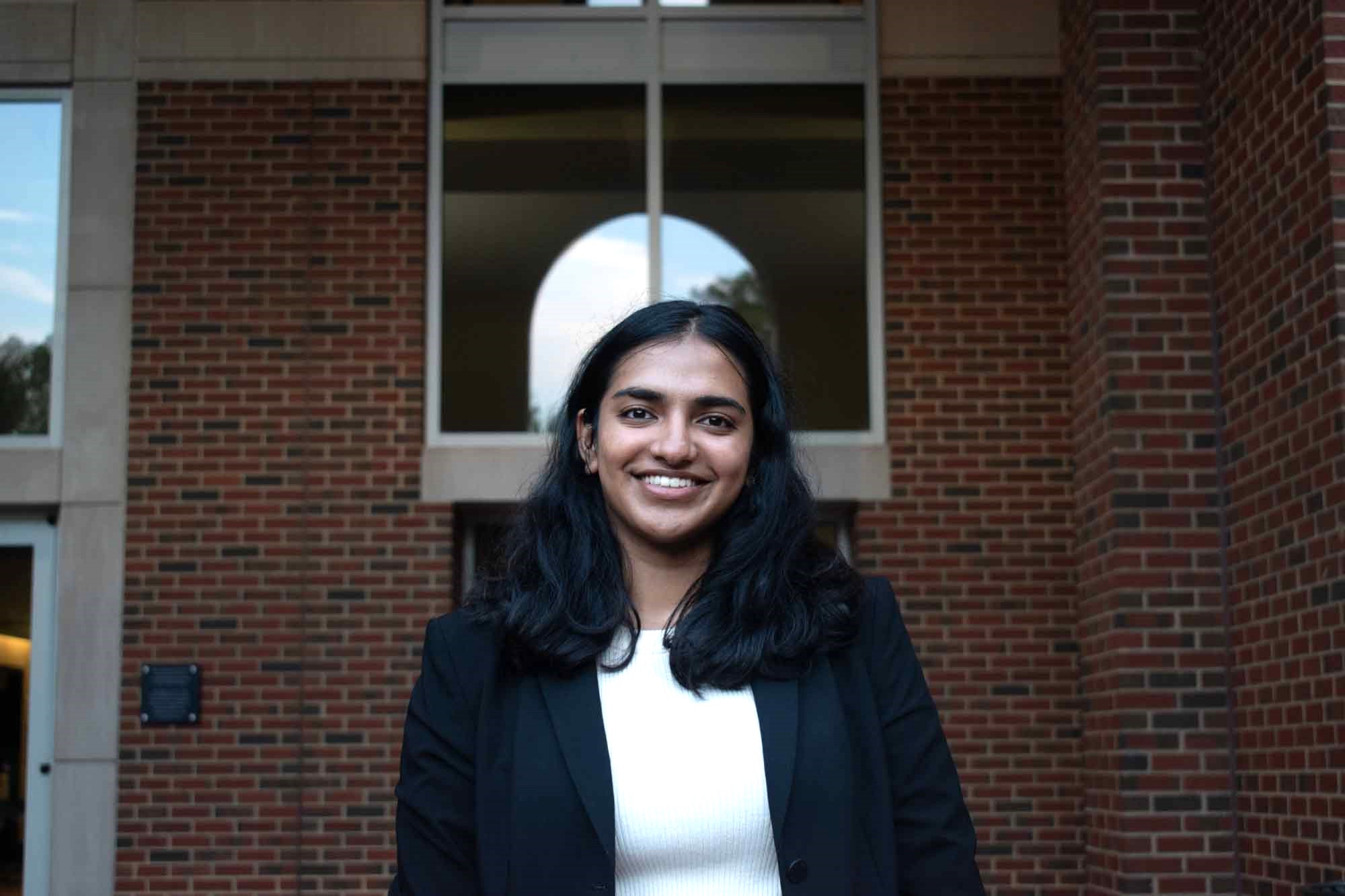 Portrait of Professional headshot of a scholar in front of a brick building