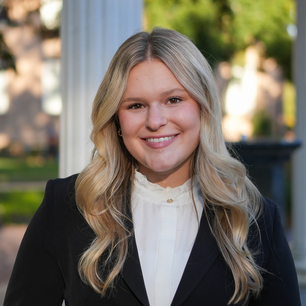Portrait of Headshot of a young woman standing outside the Old Well at UNC-Chapel Hill